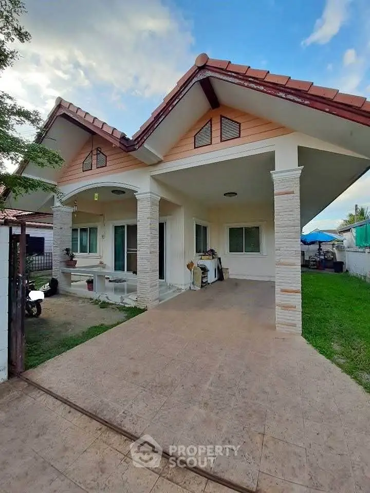 Charming single-story house with a spacious driveway and manicured lawn, perfect for family living.