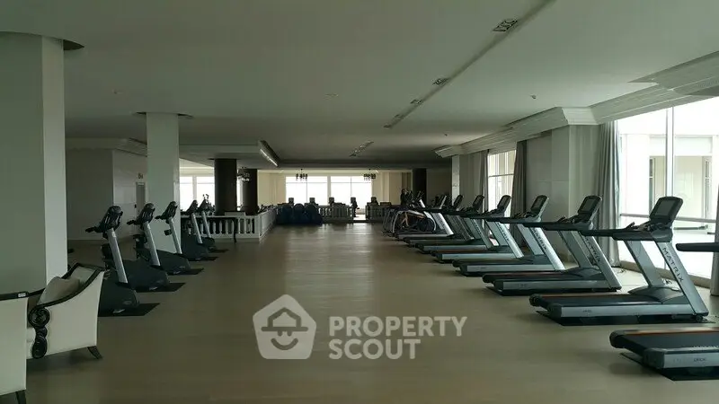 Spacious modern gym with state-of-the-art equipment in luxury residential building.