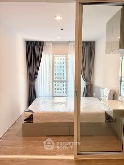 Modern bedroom with large window and elegant curtains in a stylish apartment.