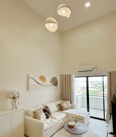 Spacious living room with modern decor and balcony view, perfect for relaxation and entertainment.