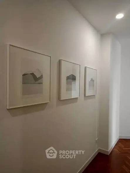 Elegant hallway with modern art and wooden flooring in a stylish home interior.