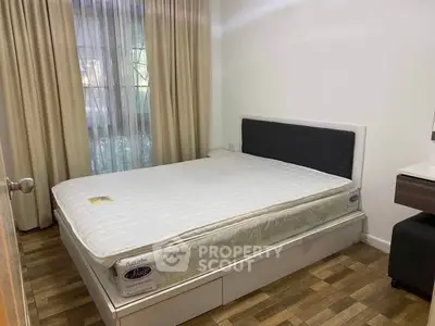 Cozy bedroom with large window and modern bed frame, perfect for restful nights.