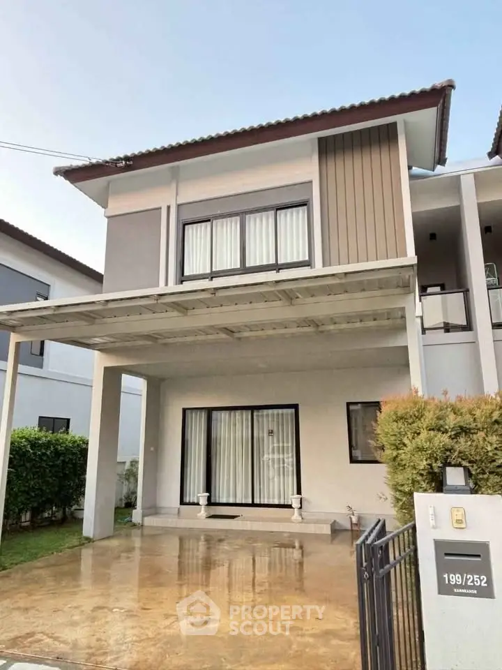 Modern two-story house with a sleek design and spacious driveway in a suburban neighborhood.