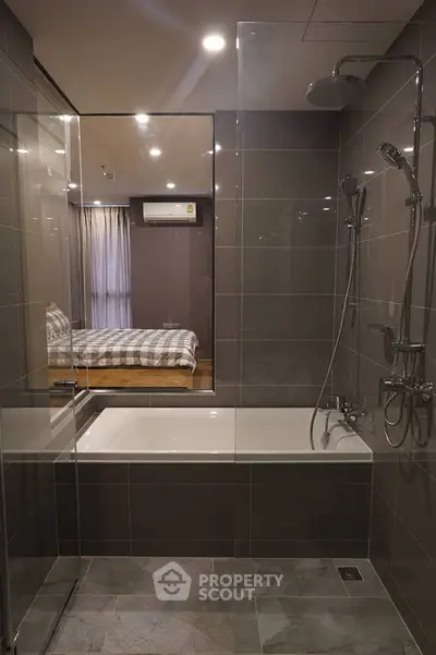 Modern bathroom with glass shower and bathtub in stylish apartment