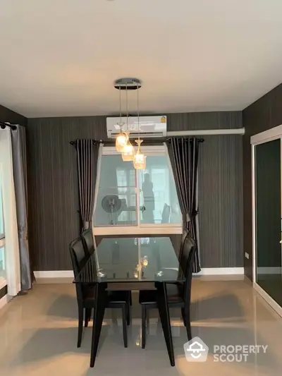 Modern dining room with sleek black furniture and elegant lighting in a stylish apartment.