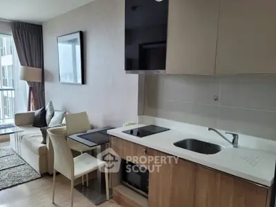 Modern open-layout kitchen and living room with sleek design and natural light.