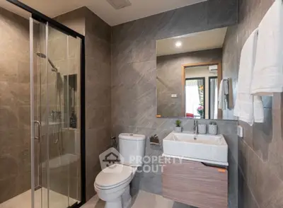 Modern bathroom with sleek shower and elegant vanity in contemporary home.