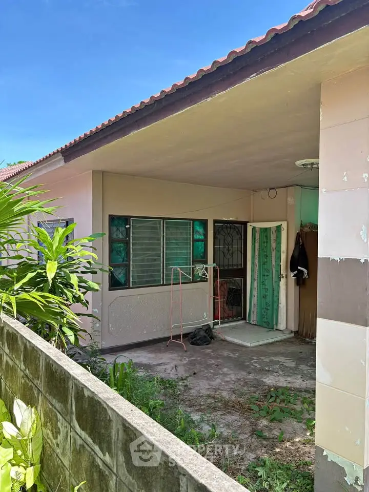 Charming single-story home with covered patio and lush greenery, perfect for outdoor relaxation.