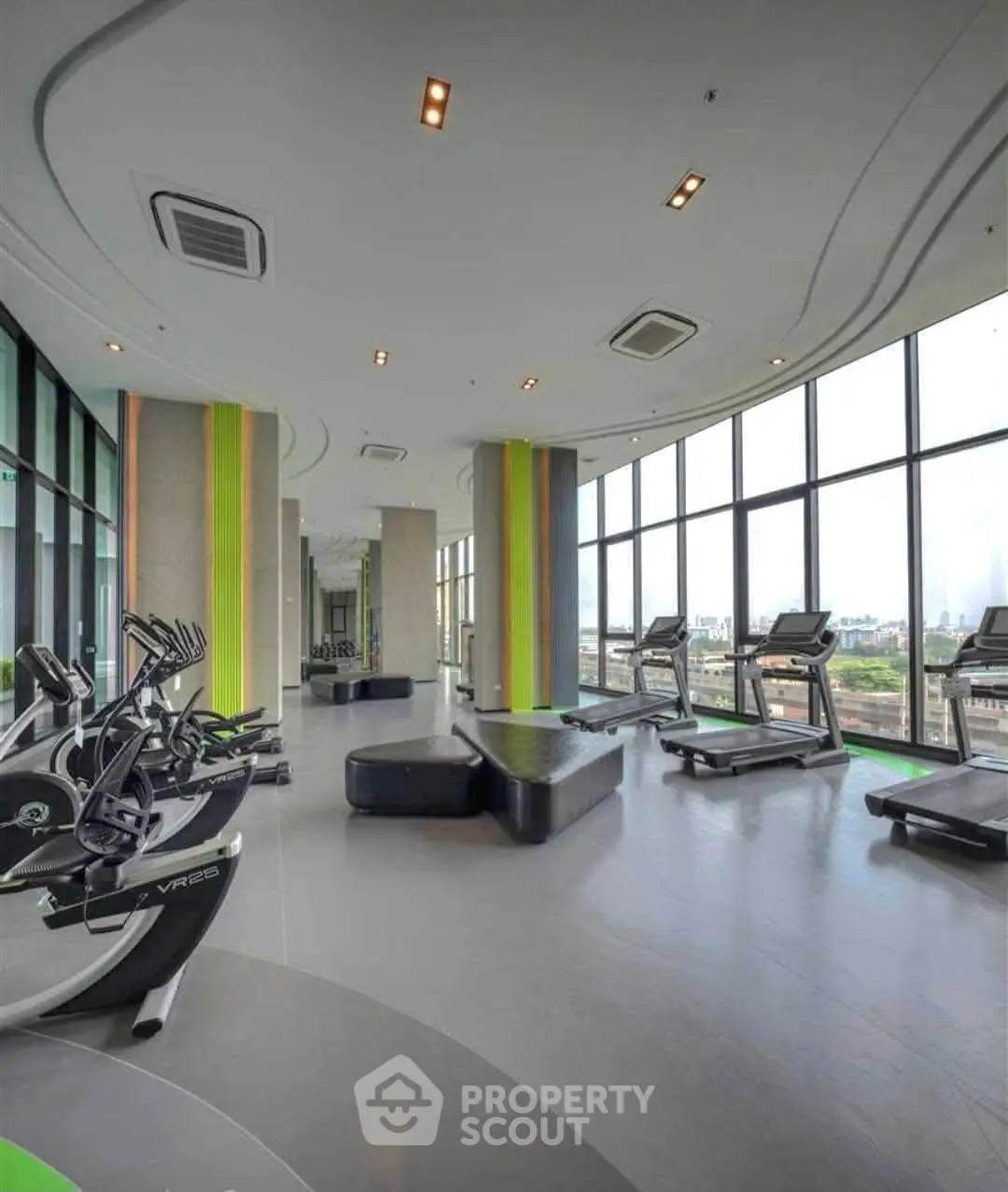 Modern gym with panoramic city views and state-of-the-art fitness equipment in luxury high-rise building.