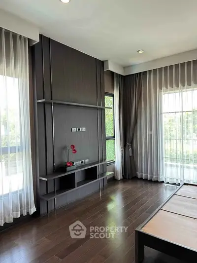 Spacious modern living room with large windows and elegant curtains