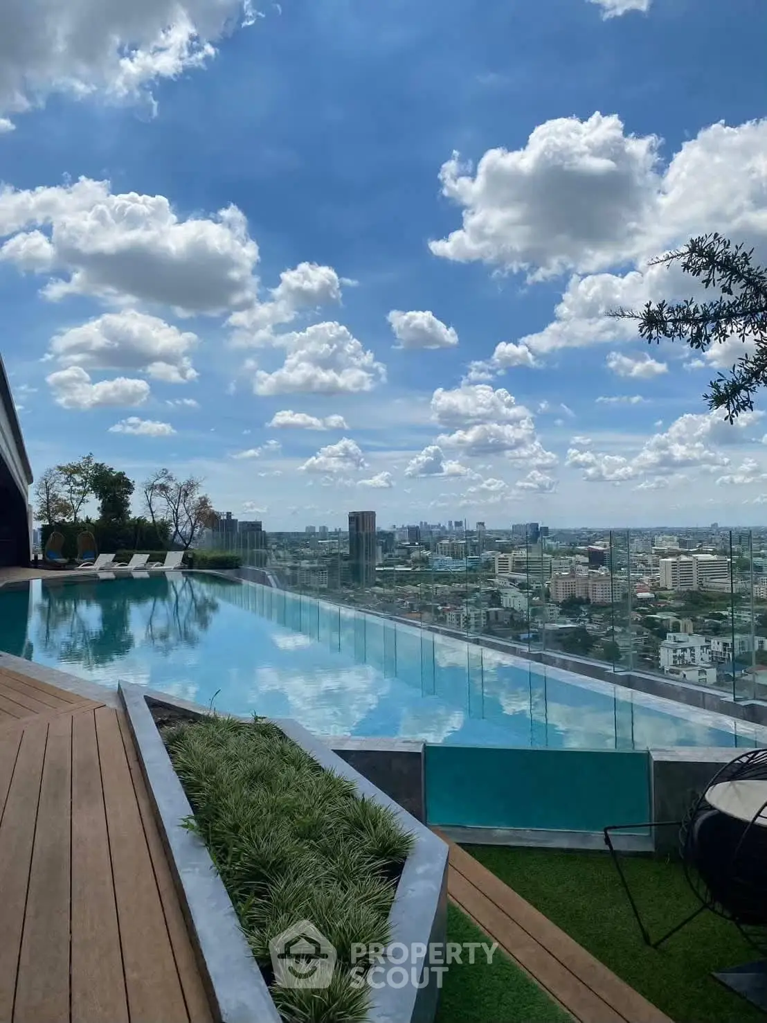 Stunning rooftop infinity pool with panoramic city views and lush greenery.