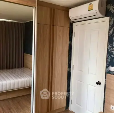Modern bedroom with built-in wardrobe and air conditioning unit, featuring stylish decor and cozy ambiance.