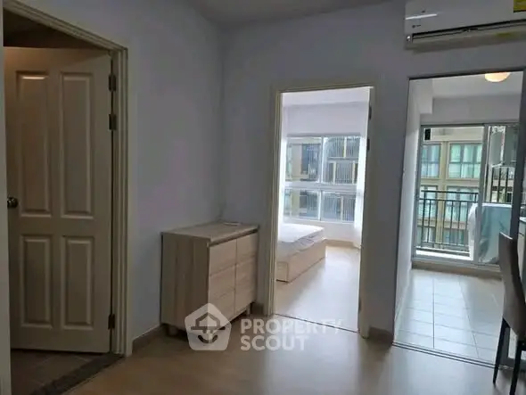 Bright apartment interior with bedroom and balcony view, featuring modern furniture and ample natural light.