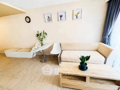 Bright and modern living room with cozy beige sofa, elegant decor, and natural light from large window.