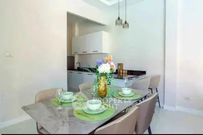Modern dining area with elegant table setting and open kitchen layout