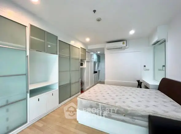 Spacious bedroom with built-in storage and modern air conditioning unit