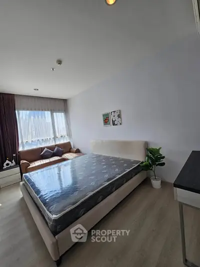 Spacious bedroom with natural light, featuring a cozy bed and stylish decor, perfect for relaxation.