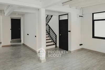 Spacious and modern living area with elegant staircase, sleek flooring, and ample natural light, perfect for stylish urban living.