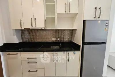 Modern kitchen with sleek cabinetry and stainless steel fridge