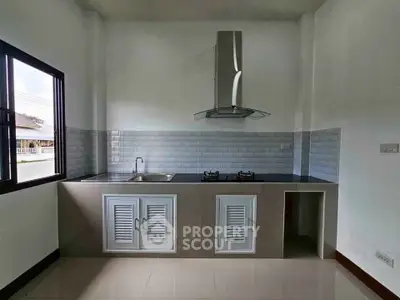 Modern kitchen with sleek gas stove and stylish range hood in a bright, minimalist design.