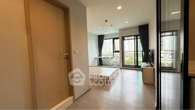 Modern apartment interior with spacious living area and large windows offering city views.