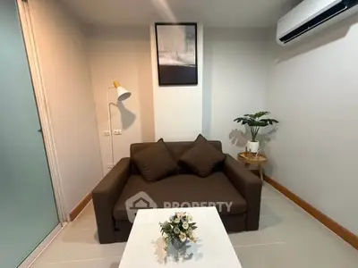 Cozy living room with modern decor and air conditioning, perfect for relaxation.