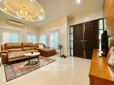 Elegant living room with leather sofas, chandelier, and stylish decor