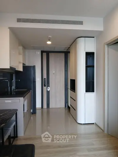 Modern apartment entrance with sleek kitchen and stylish cabinetry