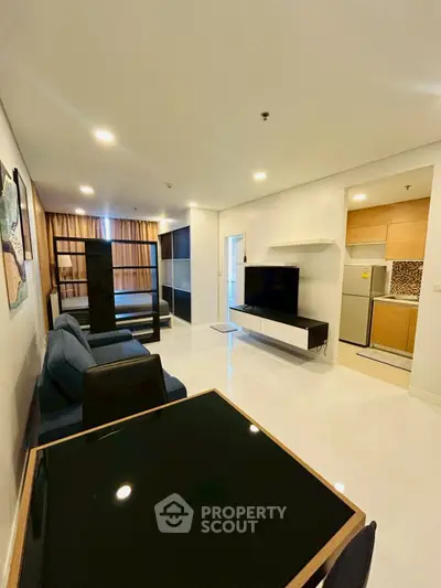 Modern living room with sleek furniture and open kitchen in a stylish apartment.