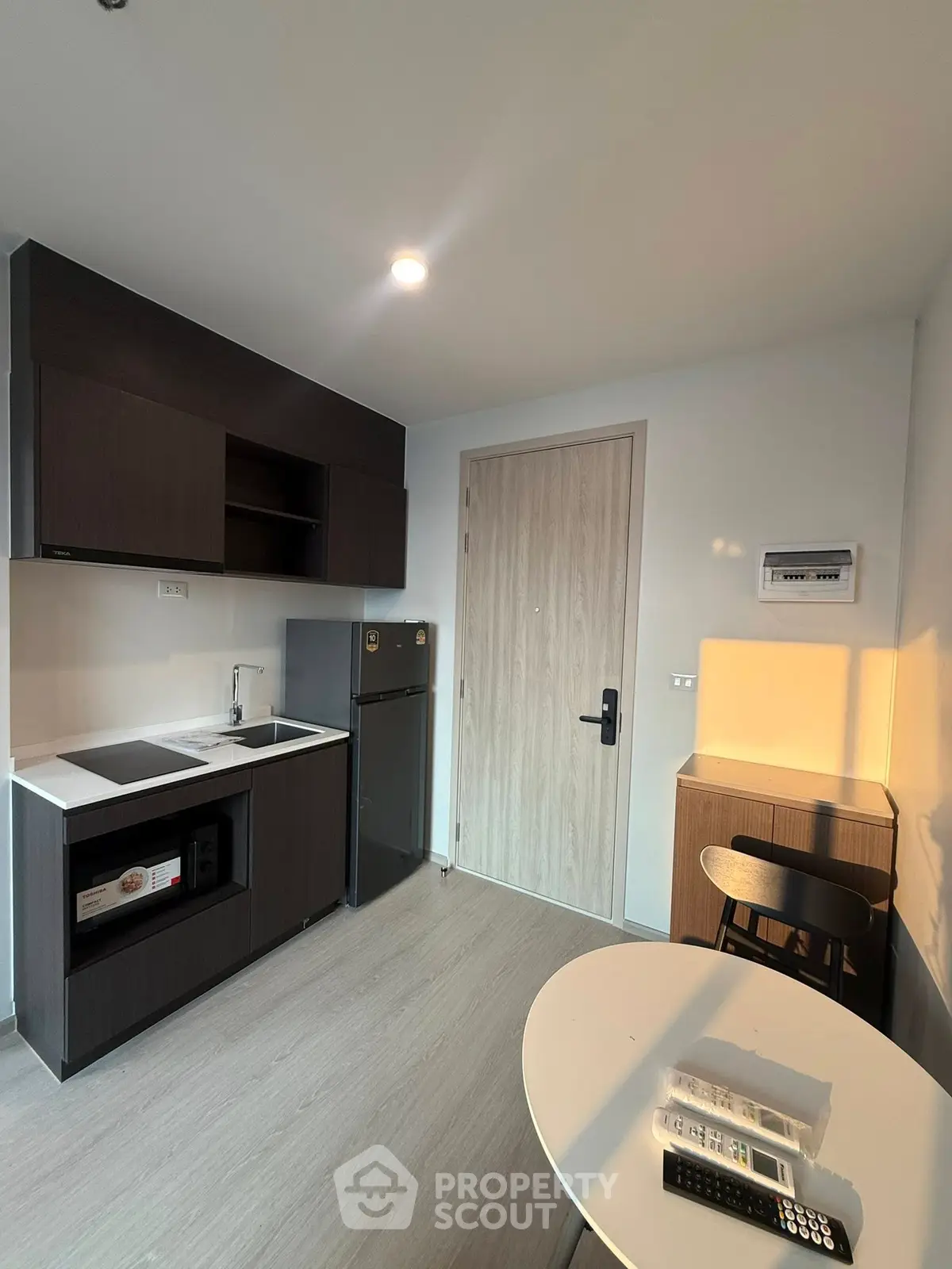 Modern compact kitchen with sleek cabinetry and integrated appliances in a cozy apartment.