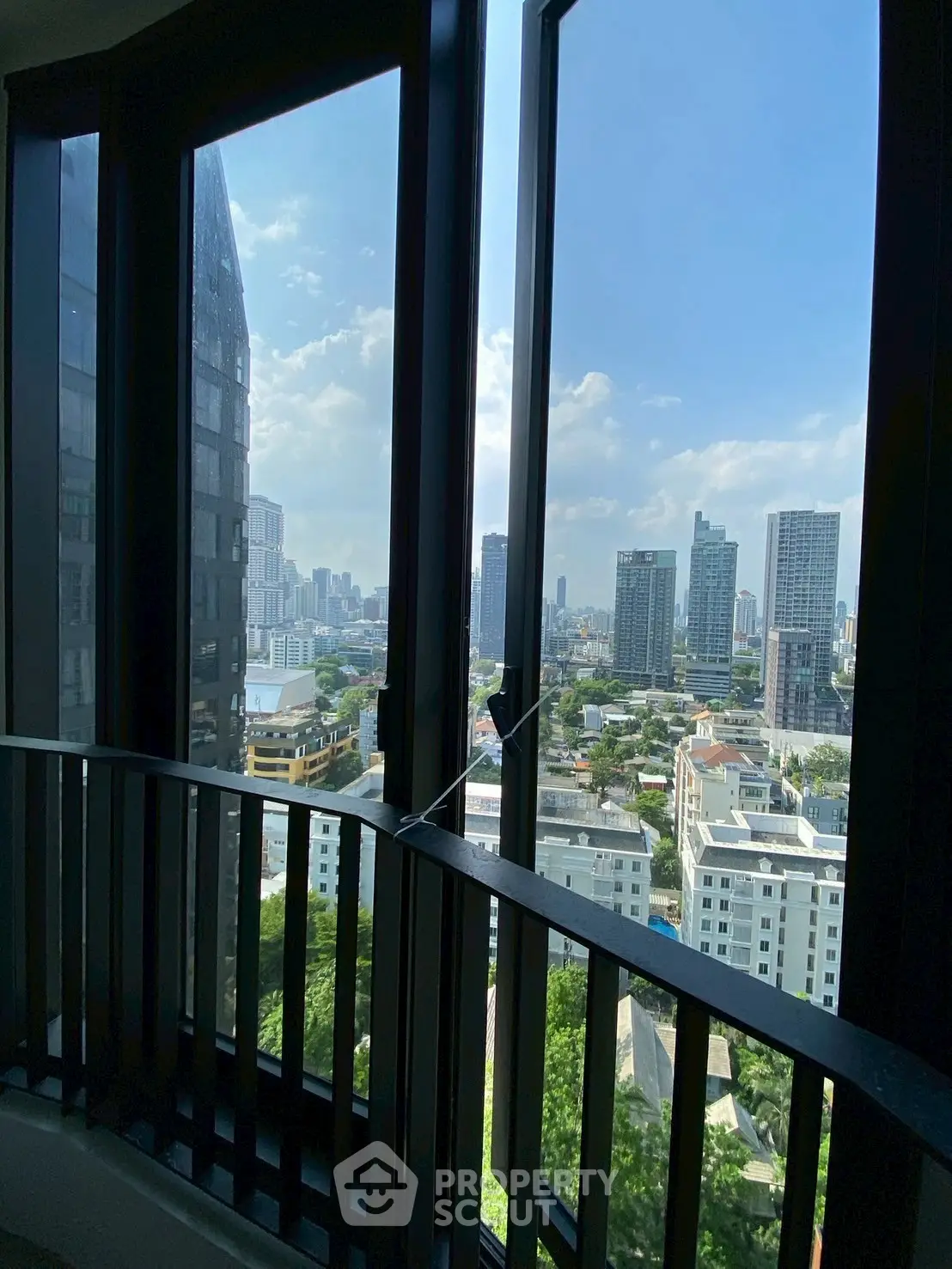 Stunning cityscape view from high-rise building window, showcasing urban skyline and blue sky.