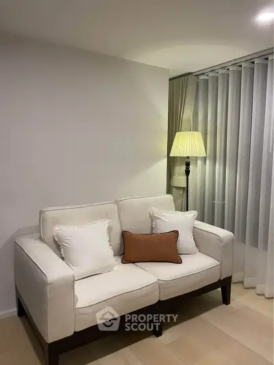 Cozy living room with elegant sofa and floor lamp, perfect for relaxation.