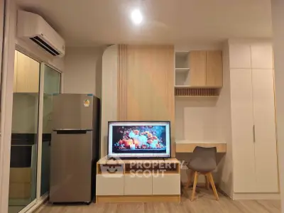 Modern living room with sleek furniture and built-in storage, featuring a TV and air conditioning.