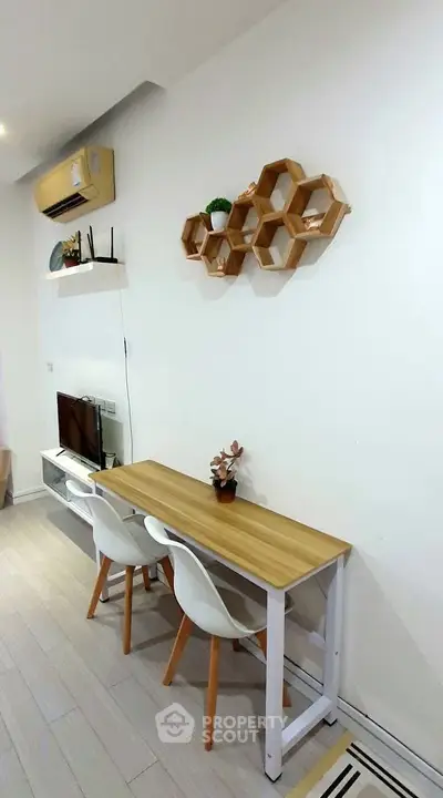 Modern living room with stylish wall decor and compact dining area, perfect for urban living.