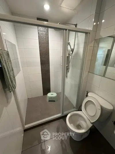 Modern bathroom with glass shower enclosure and sleek tile design.