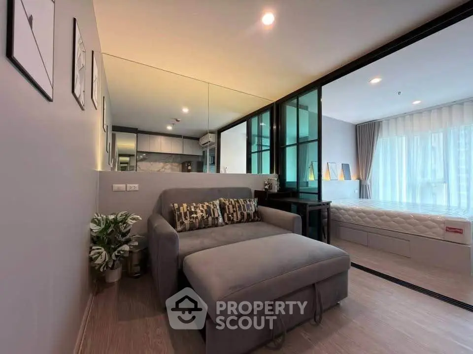 Modern studio apartment with open layout, featuring cozy living area and stylish bedroom.