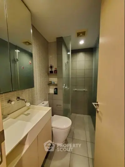 Modern bathroom with sleek design, glass shower, and stylish fixtures in a contemporary apartment.