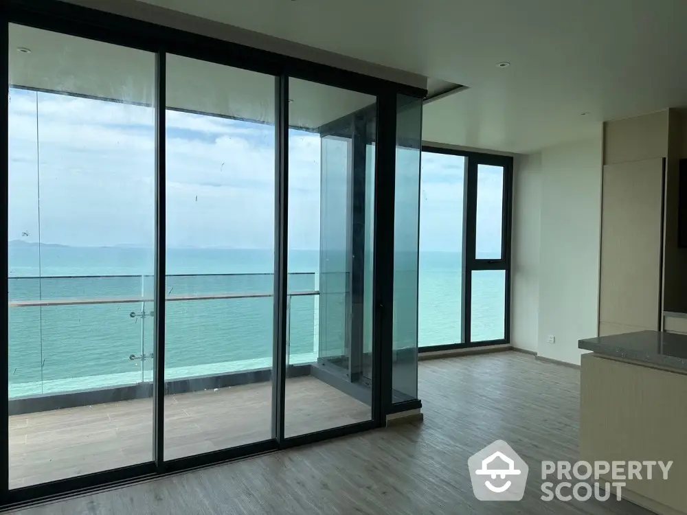 Stunning oceanfront apartment with floor-to-ceiling windows and spacious balcony.