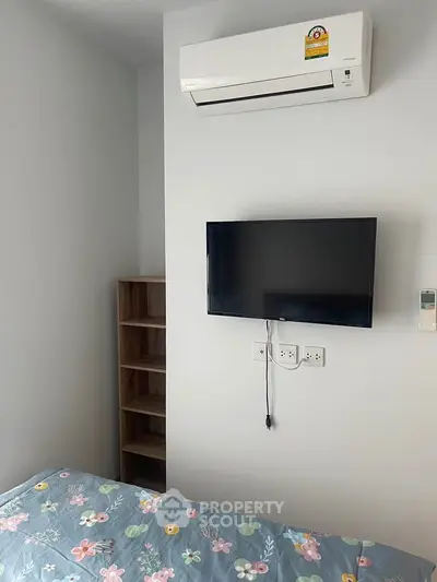 Cozy bedroom with air conditioning and wall-mounted TV, perfect for relaxation.