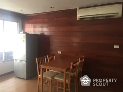 Cozy dining area with wooden wall and air conditioning in modern apartment