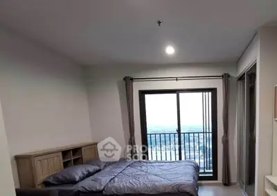 Spacious bedroom with large window offering stunning city view, perfect for relaxation and comfort.