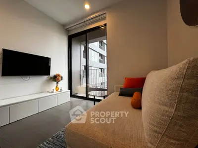 Modern living room with cozy sofa, wall-mounted TV, and balcony view in stylish apartment.
