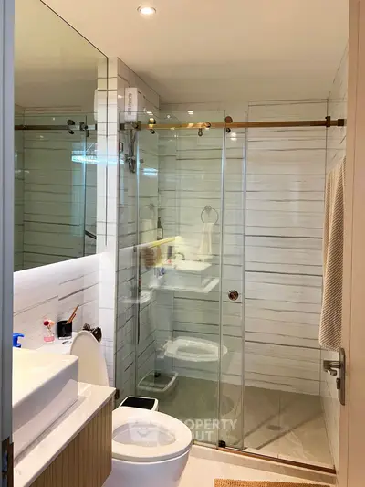 Modern bathroom with glass shower enclosure and sleek fixtures