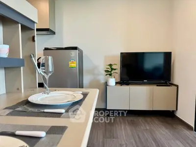 Modern living room with sleek furniture and compact kitchen area, perfect for urban living.