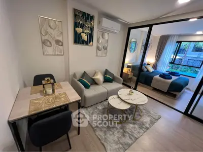 Modern open-plan living room with elegant decor and cozy bedroom view, perfect for urban living.