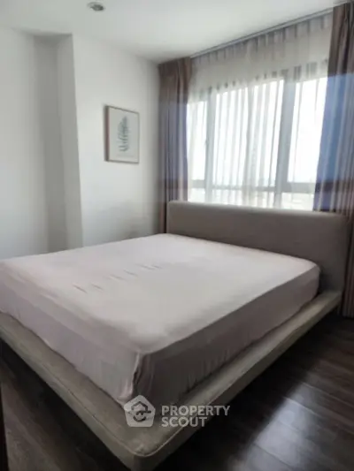 Cozy bedroom with large window and modern decor in a stylish apartment.