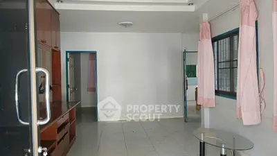 Spacious living room with glass table and large windows, perfect for natural light.