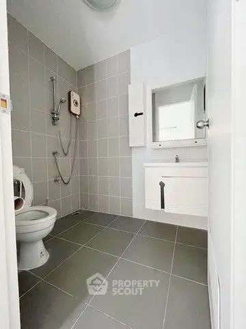 Modern bathroom with sleek gray tiles and white fixtures