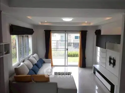 Modern living room with large windows and stylish furniture, offering a bright and inviting atmosphere.