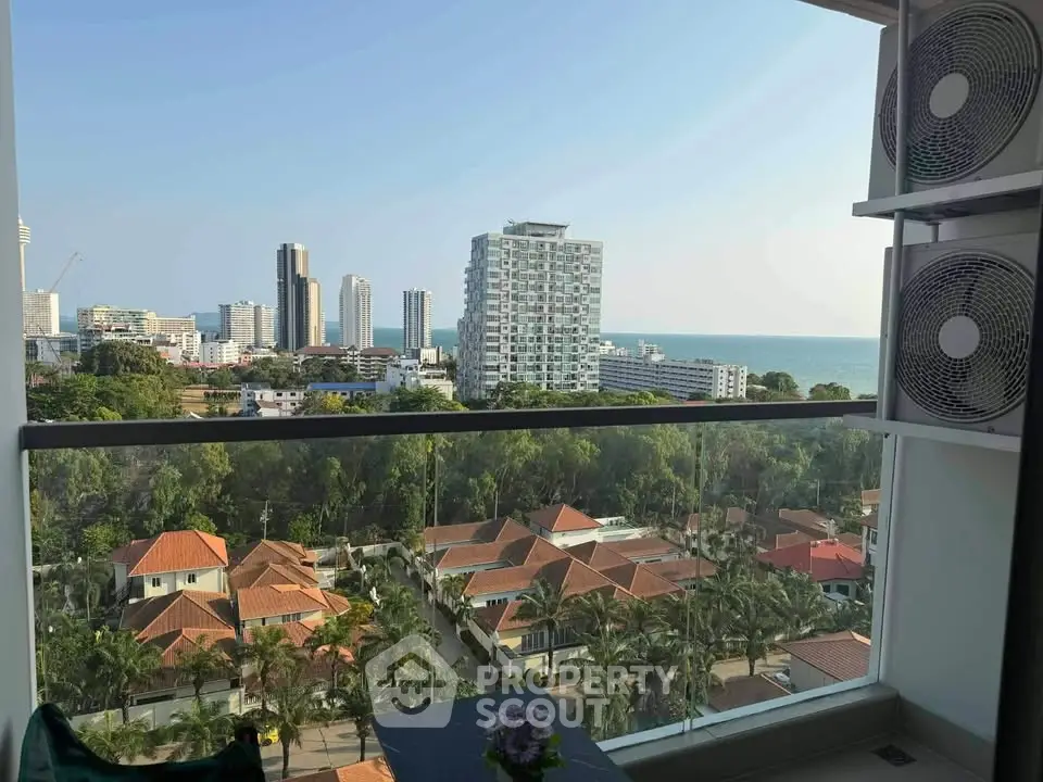 Stunning high-rise balcony view overlooking cityscape and ocean, perfect for urban living.